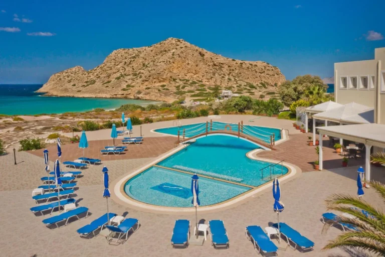 Seaside resort pool overlooking turquoise bay and rocky hill