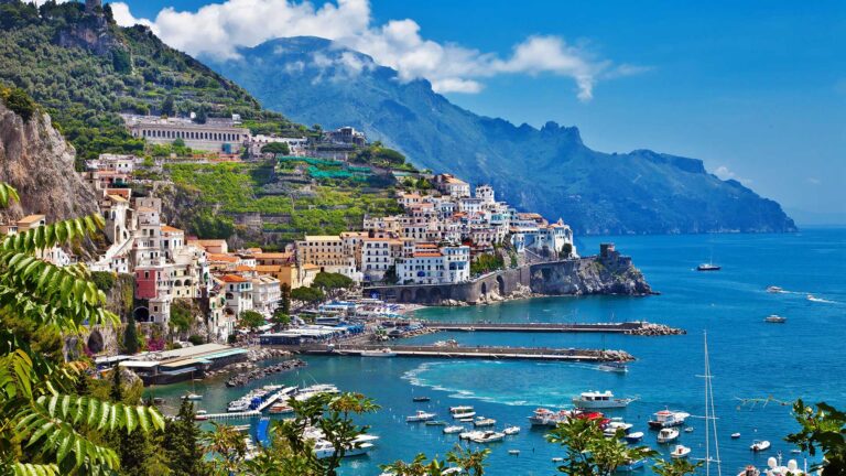 Colorful Amalfi Coast town overlooking turquoise Mediterranean harbor