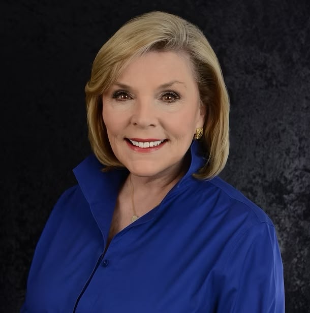 Professional headshot of smiling blonde woman in blue blouse
