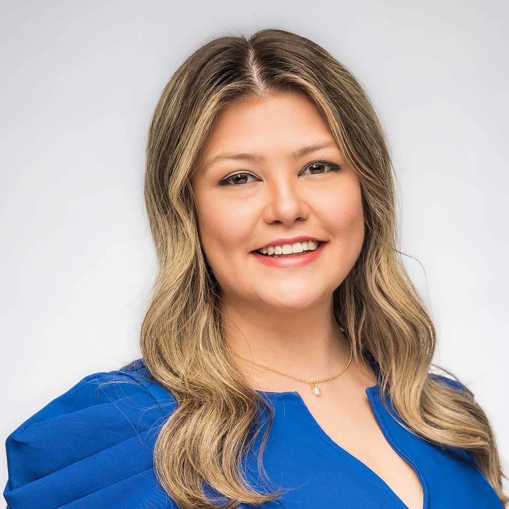 Smiling woman in blue blouse, studio headshot